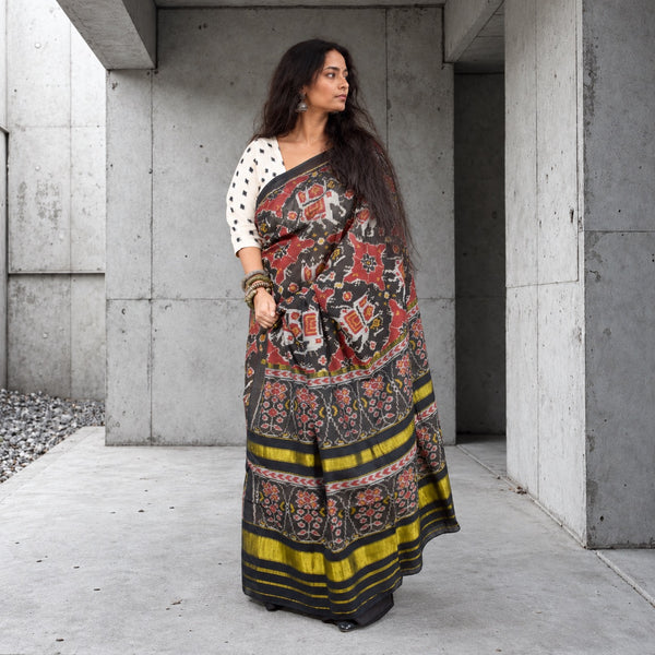 KUNJAR BHAT BLACK-FIRE BRICK RED SINGLE IKAT COTTON PATOLA SAREE WITH ZARI ANCHAL
